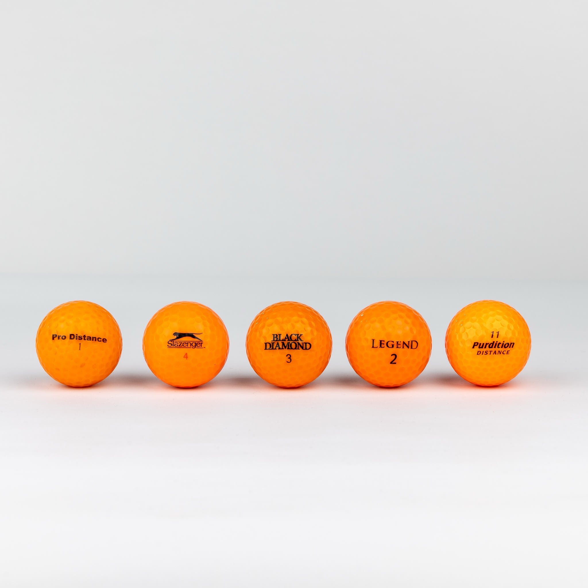 Gekleurde golfballen (roze, oranje, geel)